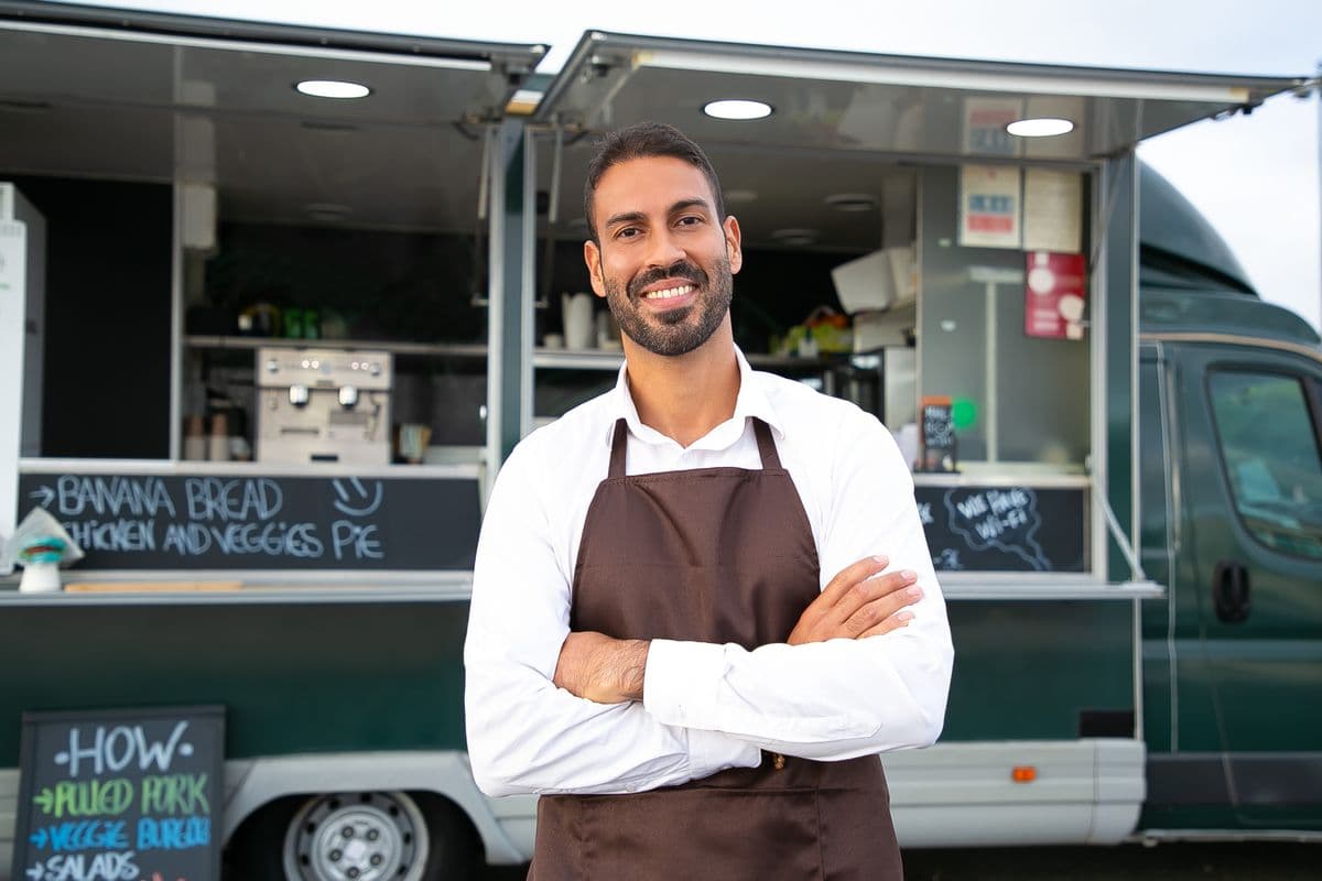 A food truck owner standing in front of his business